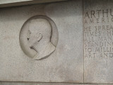 Shaft with bench beside it (all one piece) with sunken bas-relief medallion above the bench