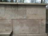 Shaft with bench beside it (all one piece) with sunken bas-relief medallion above the bench