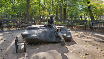 Two figures and chair on a natural boulder, mosaic play surface