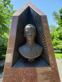 Bust (life size) recessed in pyramidal monument, two plaques with reliefs