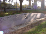 Low, crescent-shaped granite wall with bas-relief medallion of Verazzano and inscription