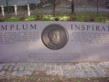 Low, crescent-shaped granite wall with bas-relief medallion of Verazzano and inscription