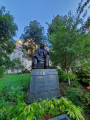 Seated figure (over life-size) on integral plinth, on pedestal