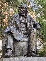 Seated figure (over life-size) on integral plinth, on pedestal