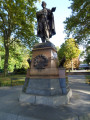 Standing figure (over life-size) on integral plinth on pedestal with wreaths and insignia of US Army and Navy at front and rear, and two eagles, one proper left and one proper right