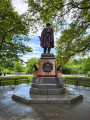 Standing figure (over life-size) on integral plinth on pedestal with wreaths and insignia of US Army and Navy at front and rear, and two eagles, one proper left and one proper right