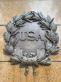 Standing figure (over life-size) on integral plinth on pedestal with wreaths and insignia of US Army and Navy at front and rear, and two eagles, one proper left and one proper right