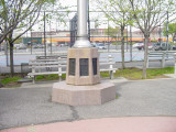 Flagstaff on base with relief plaque and two other plaques