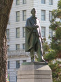 Standing figure (over life-size) with integral plinth on pedestal