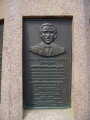 Flagstaff on base with relief plaque and two other plaques