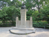 Bust on a high central stele joined by screens to shorter side steles at right and left, the whole on a plinth resting on a semi-circular step