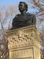 Bust on a high central stele joined by screens to shorter side steles at right and left, the whole on a plinth resting on a semi-circular step