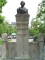 Bust on a high central stele joined by screens to shorter side steles at right and left, the whole on a plinth resting on a semi-circular step