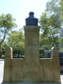 Bust on a high central stele joined by screens to shorter side steles at right and left, the whole on a plinth resting on a semi-circular step