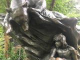 Bear on rock with faun sheltering below, and adjacent plaque