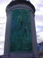 Column topped by a globe, on a circular base; column faced with three bas-reliefs; honor roll of names carved in spaces between the bas-reliefs