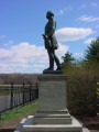 Standing figure on integral plinth, on pedestal