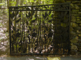 Gate of two leaves with openwork pattern, hung on two piers, with plaque mounted on one of the piers