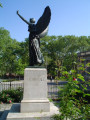 Standing female figue with integral plinth on pedestal