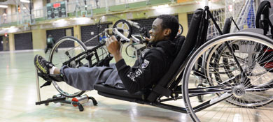 A man uses an adaptive bike at a rec center