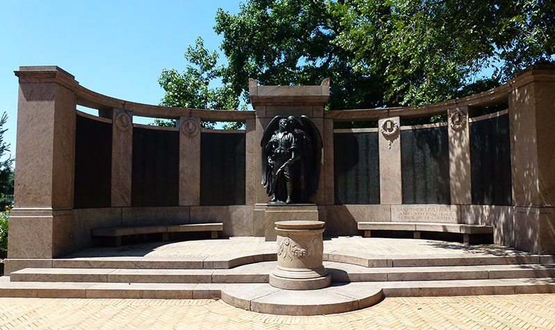 Statues of an angel of death hovering beside a dying soldier dressed in a battle outfit behind a carved granite altar. A gracefully curving wall behind the statues supports six bronze honor rolls on which are listed the names of the 2,800 Brooklyn war dead.