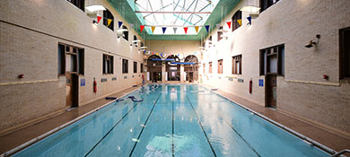 an indoor pool inside a rec center with a sun roof