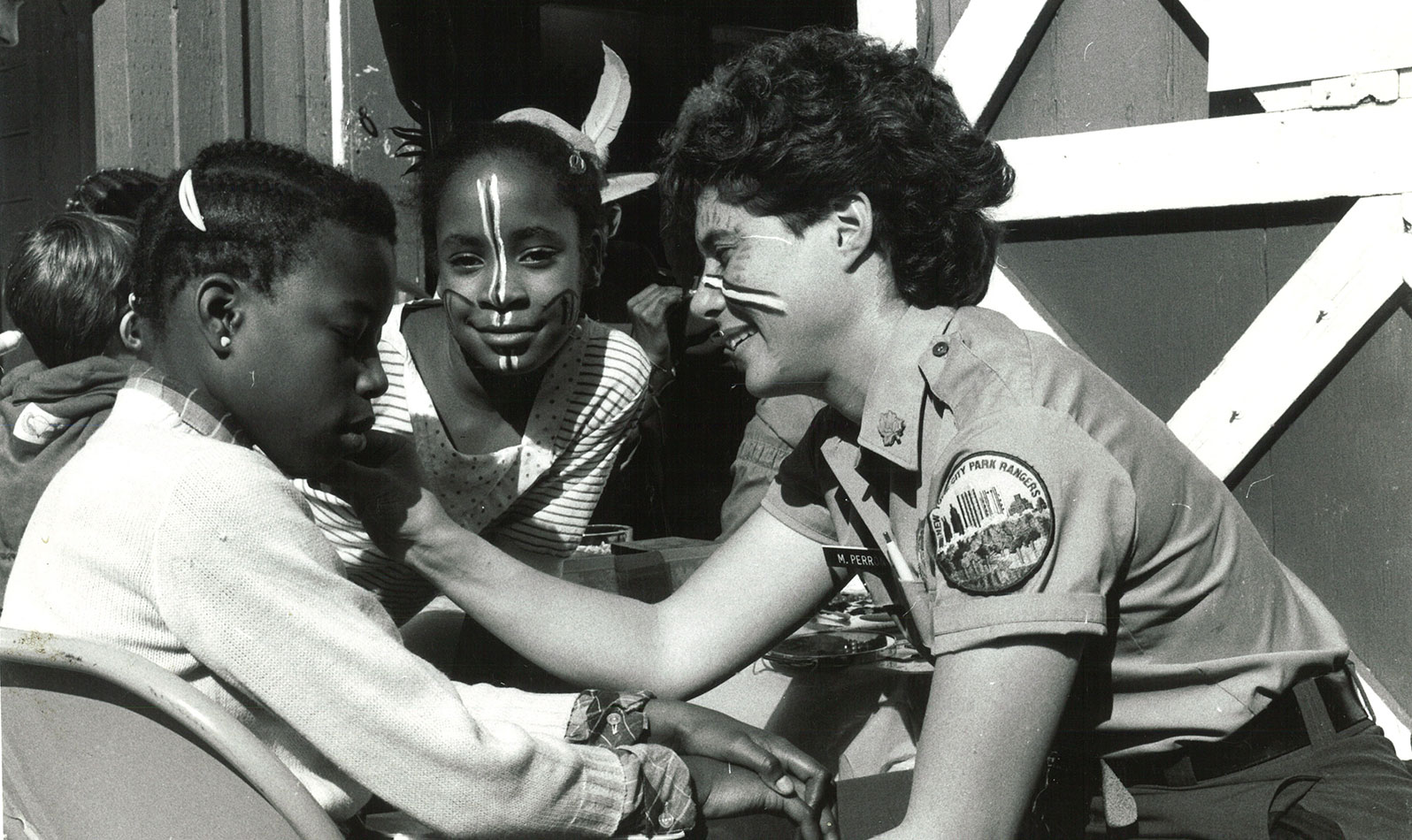 Urban Park Ranger Margot Perron paints children's faces at a public event.