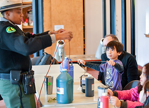 A park rangers shows kids how to tie various knots