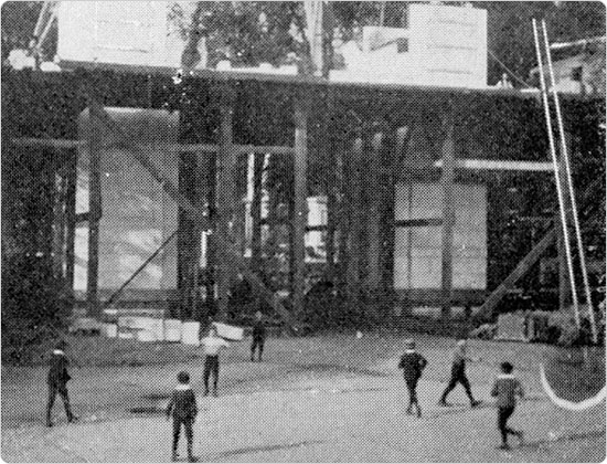 Image of Boys play baseball in the shadow of the Washington Square Arch as it is constructed, circa 1890-92.