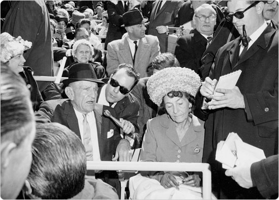 Image of Mets manager Casey Stengel and his wife Edna with reporters at Shea Stadium Opening Day, April 16, 1964. Neg. 31964.2