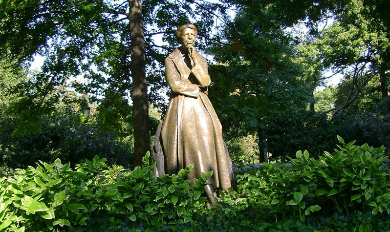 A statue of Eleanor Roosevelt stands among the greenery in Riverside Park.