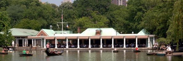 Gondoliers help paddle along the lake in front of Central Park's boathouse.