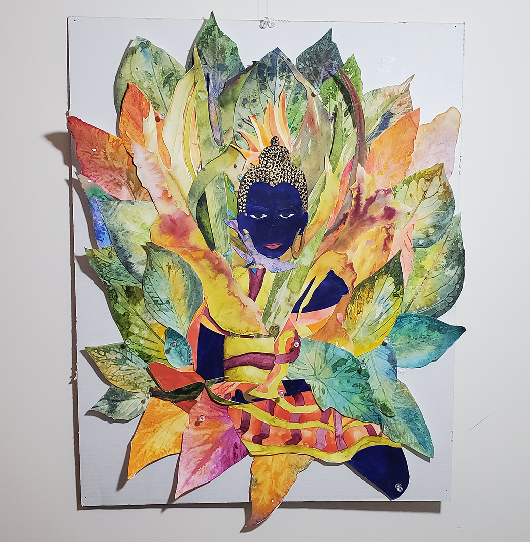 A blue Buddha is placed at the center of a drawing and surrounded by cutout paintings of leaves 