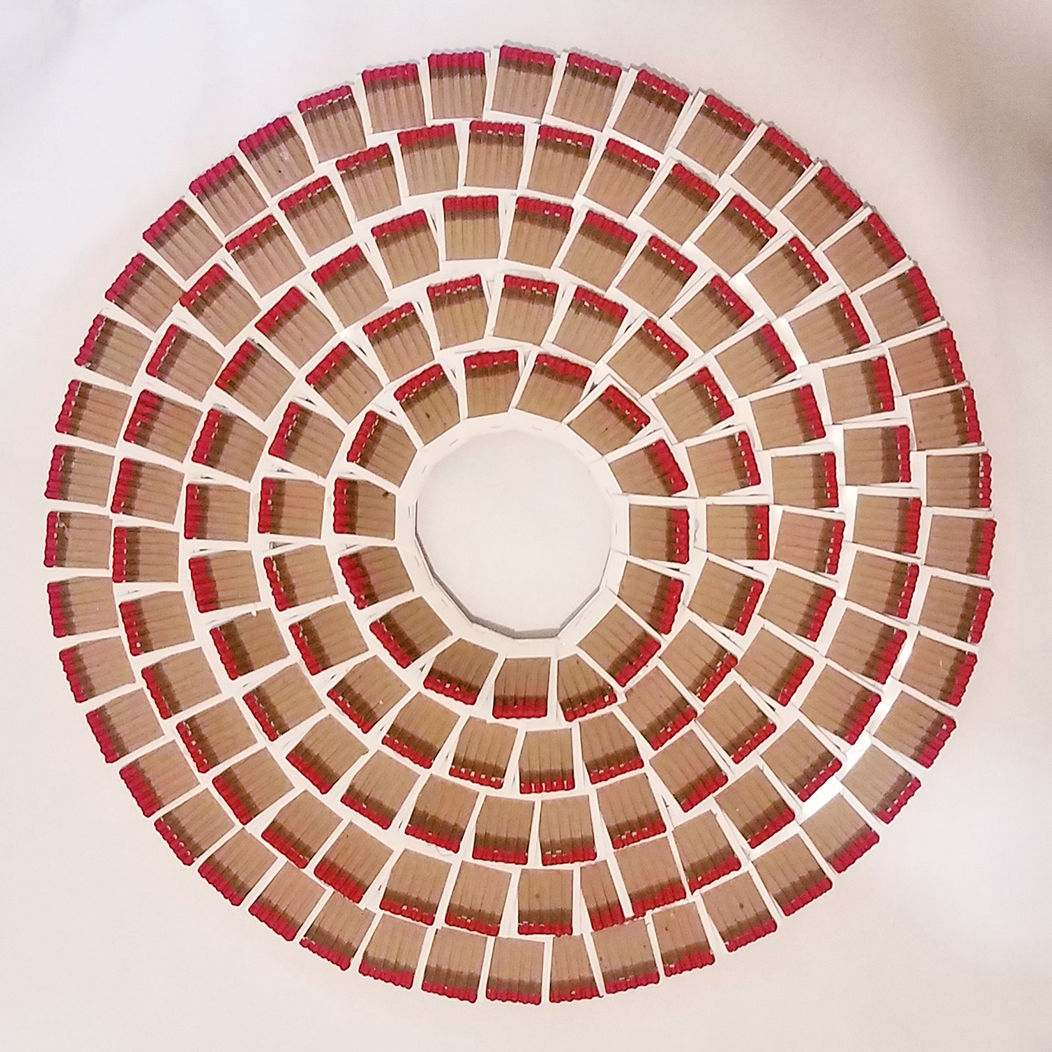 Matchbooks are arranged to form five circles within each other to form a wreath