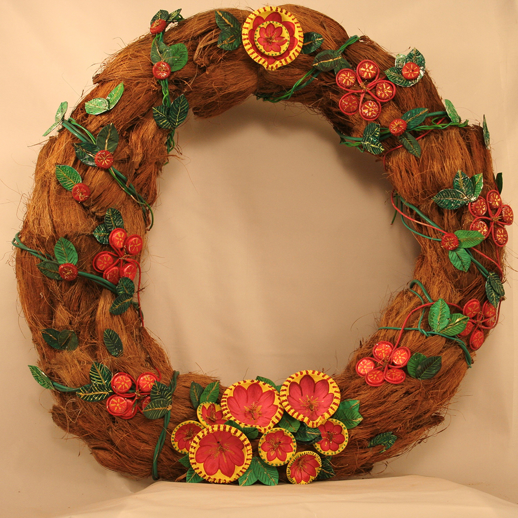 Rust colored coconut husks are wrapped in a string of ornamental leaves and red floral arrangements decorated by lamps with red and yellow floral designs