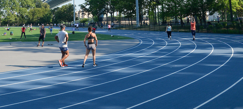 park visitors run and workout along a track in a park