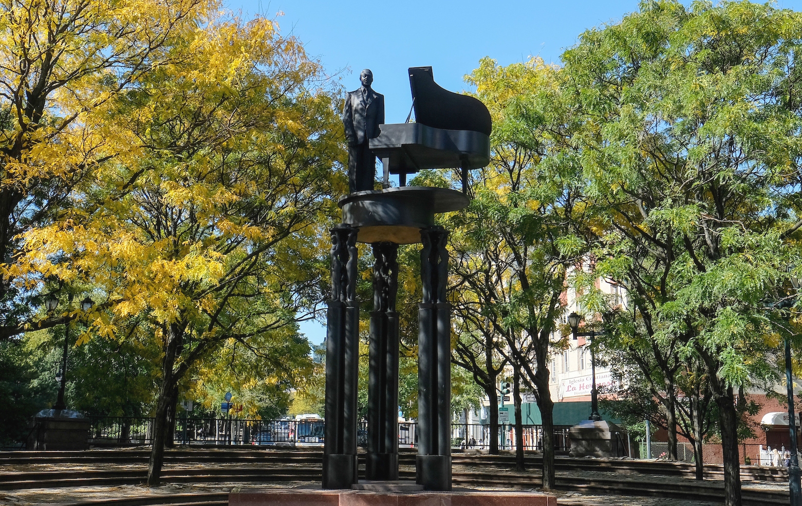 statue of duke ellington standing next a grand piano. The statue and piano stands on three columns