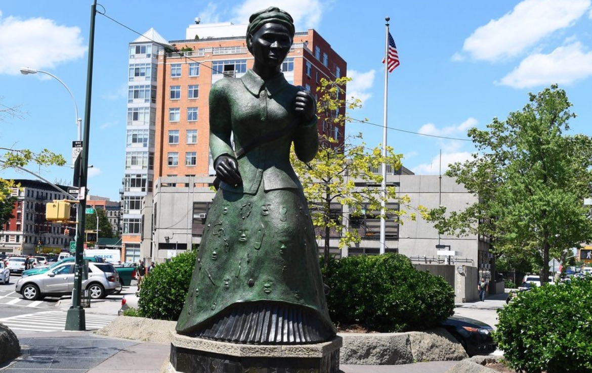 Giant statue of Harriet Tubman in a parkland at an intersection