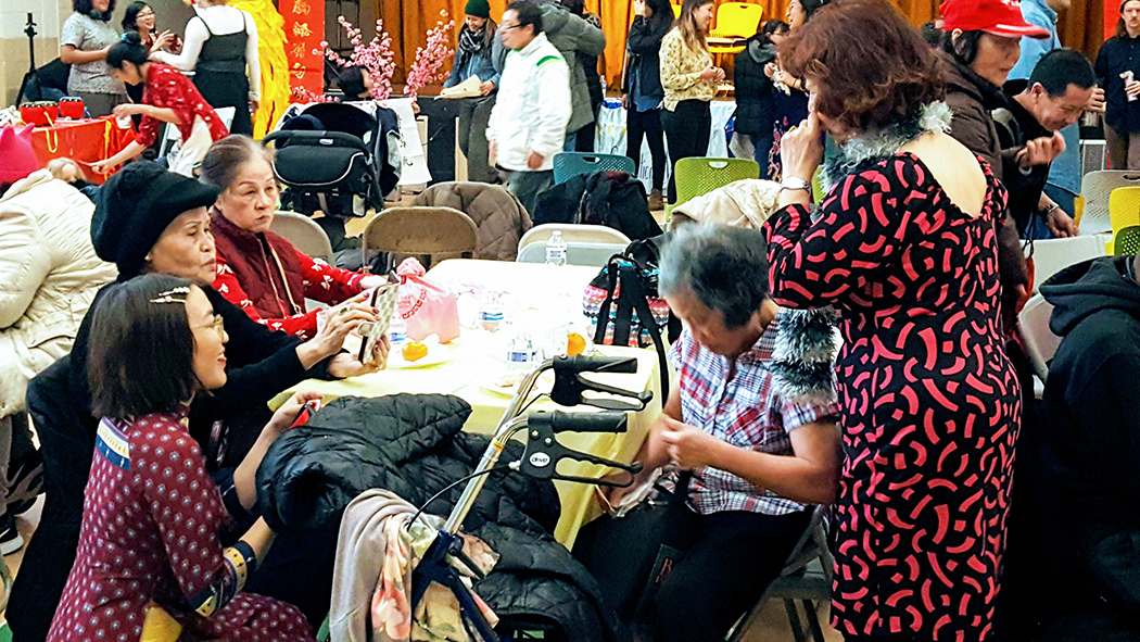 A group of seniors huddle around a table to talk about their park