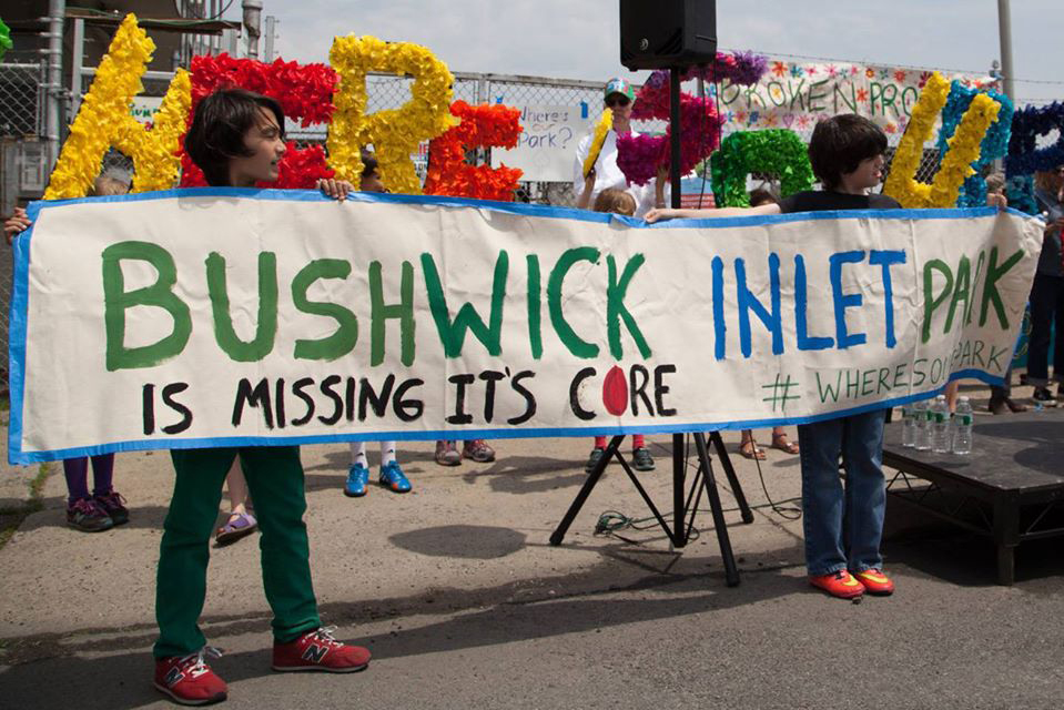 Community members hold up a sign that reads Bushwick Inlet Park is missing its core