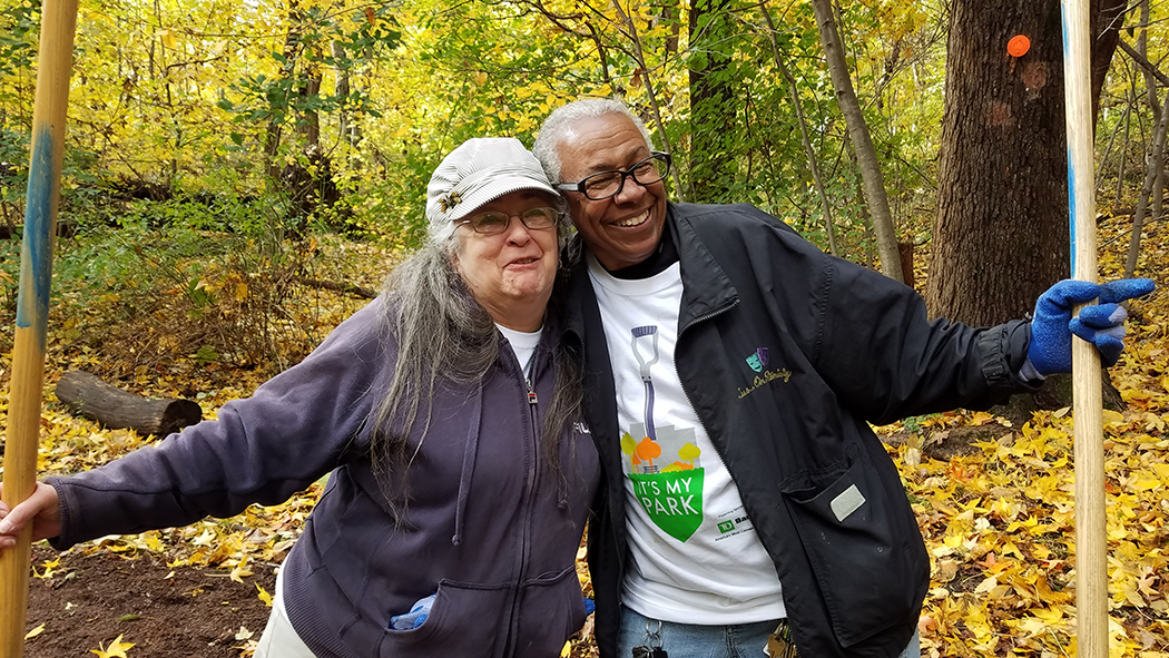 Two volunteers embrace each other in the park