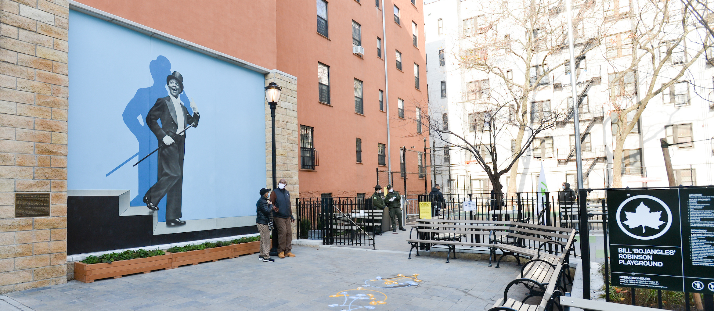 A mural in a playground area of Bill Bojangles Robinson opposite the park sign that bears his name