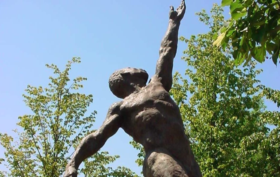 A classical nude sculpture of a human figure. One hand is extended to the sky as the figure looks up and the other is anchored to the side