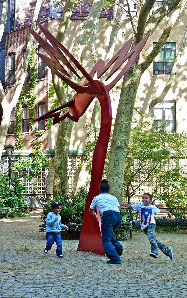 Kids play around the sculpture in the park