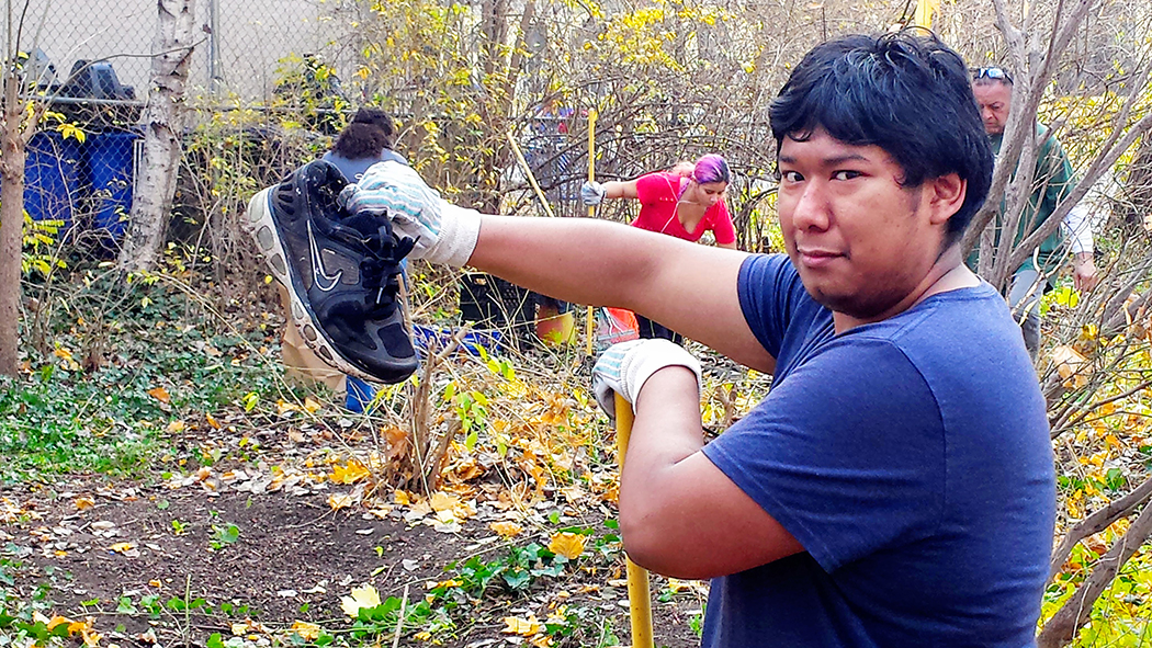 A teen volunteer holds up a shoe found while volunteering in the park