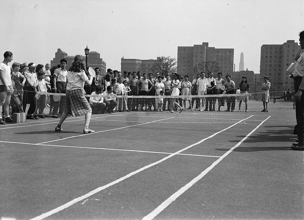 black and white archival photo of women competing in a paddle tennis contest in the park