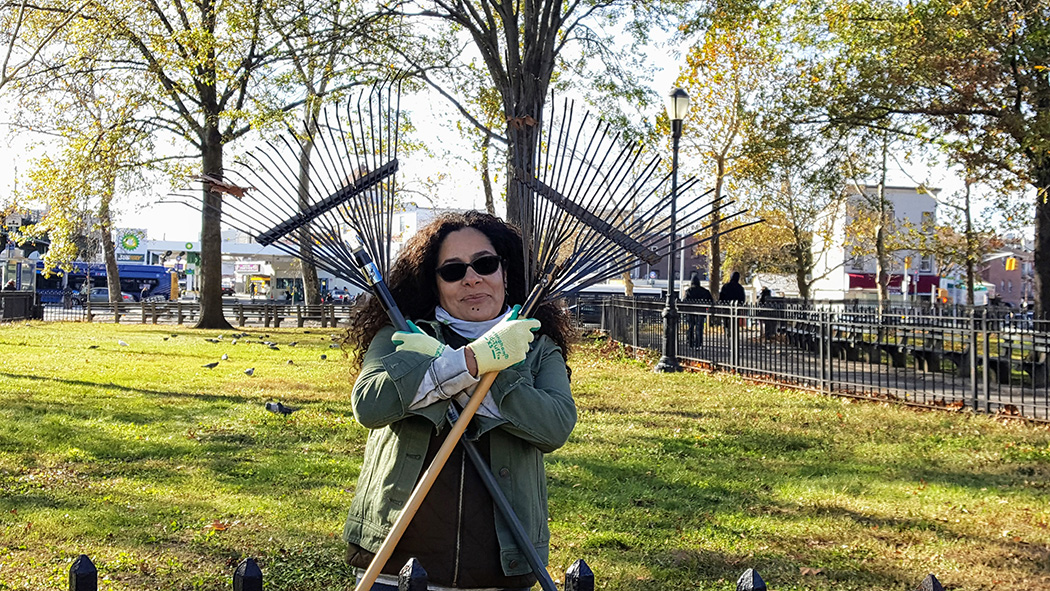 The founder holds up two rakes in an X shape