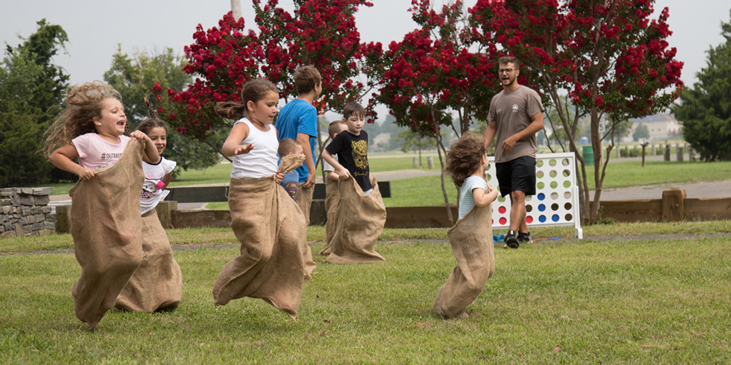 Kids hop along in a sack race in the park