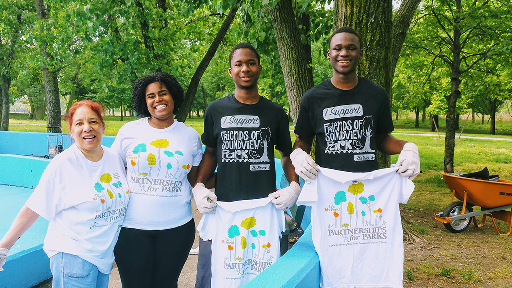 Teens and other community members pose for a photo with their It's My Park tshirts