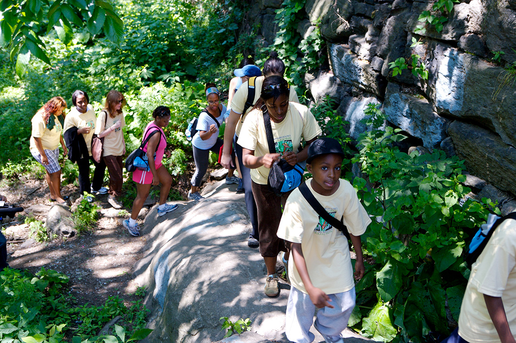 Kids walk up a rocky path in a park